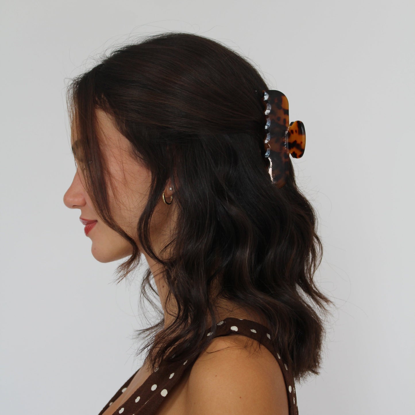 Women with short brown hair wearing black and brown tortoise claw clip