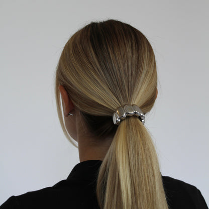 Women with blonde hair wearing a silver ponytail cuff 